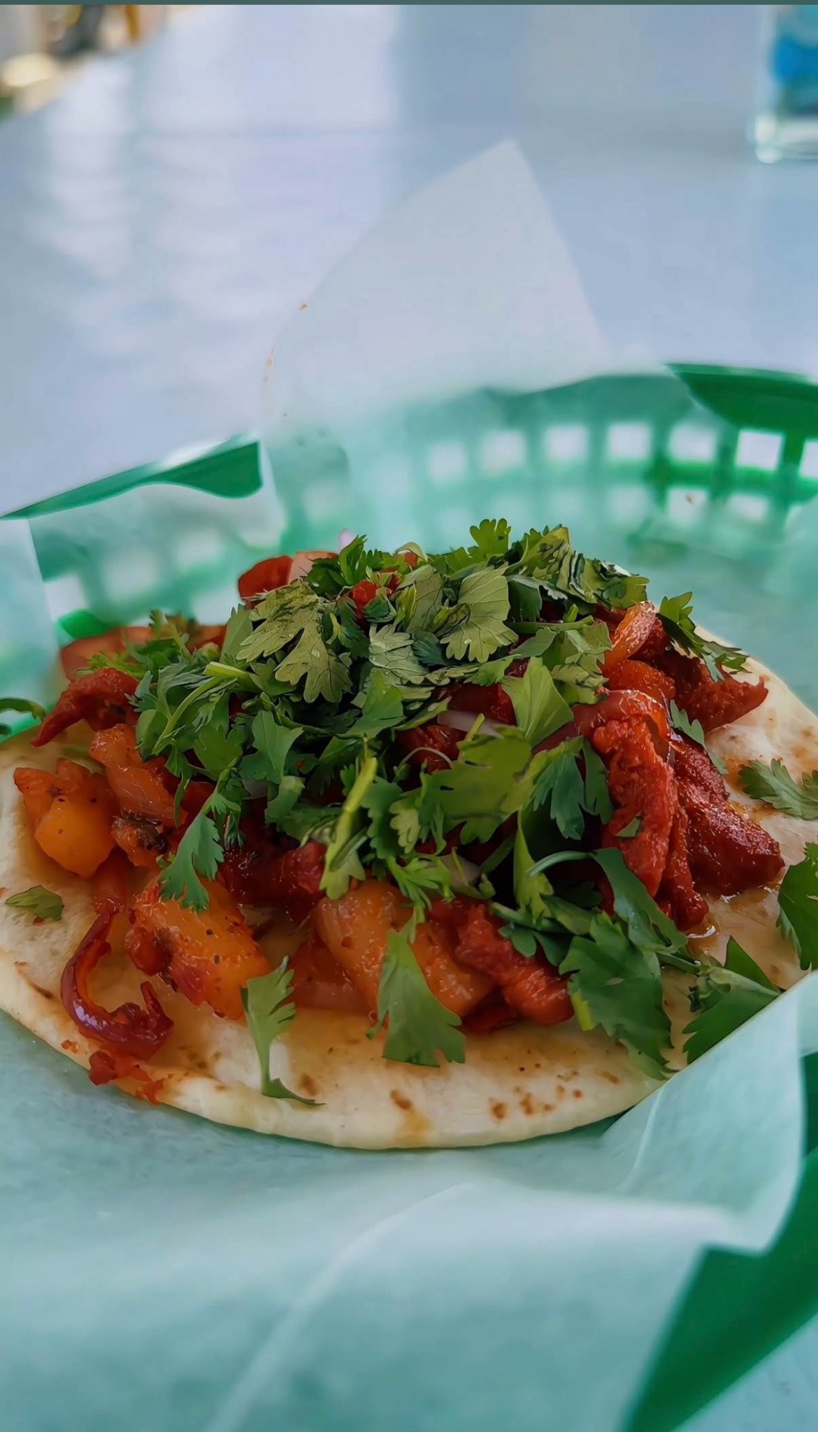 Al pastor taco topped with fresh cilantro