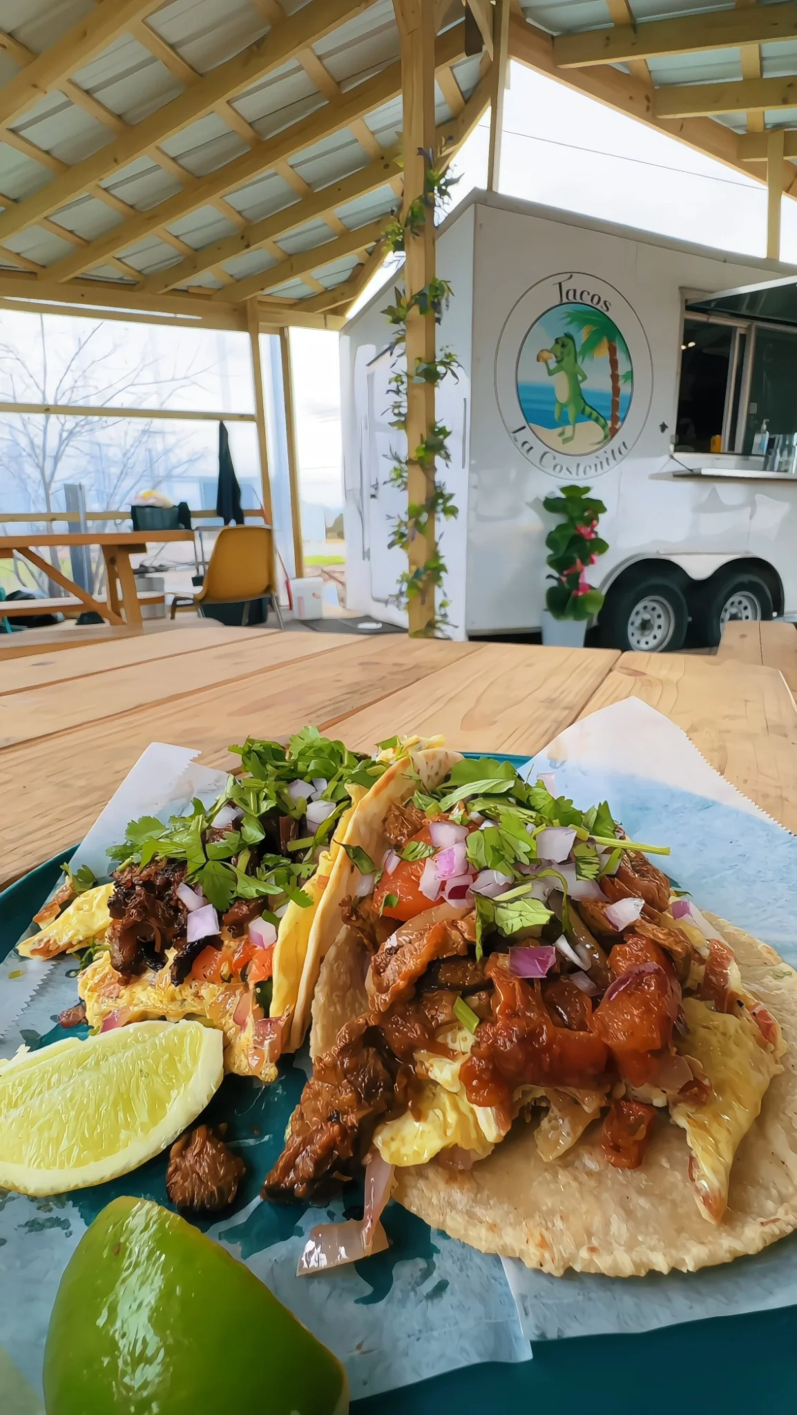 Loaded tacos served at Tacos La Costeñita with the white food truck behind them
