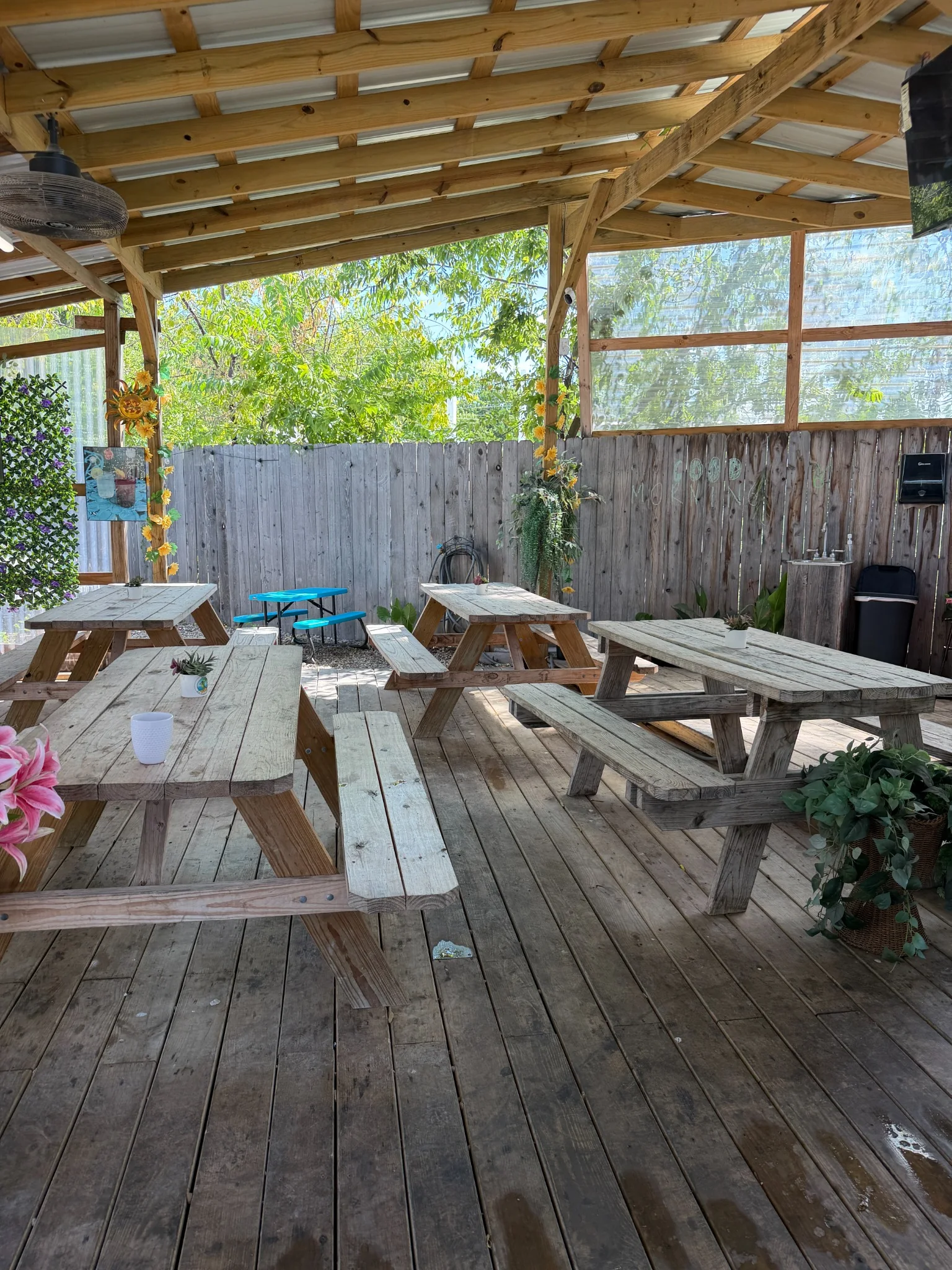 Covered patio seating at Tacos La Costeñita decorated with sunflowers