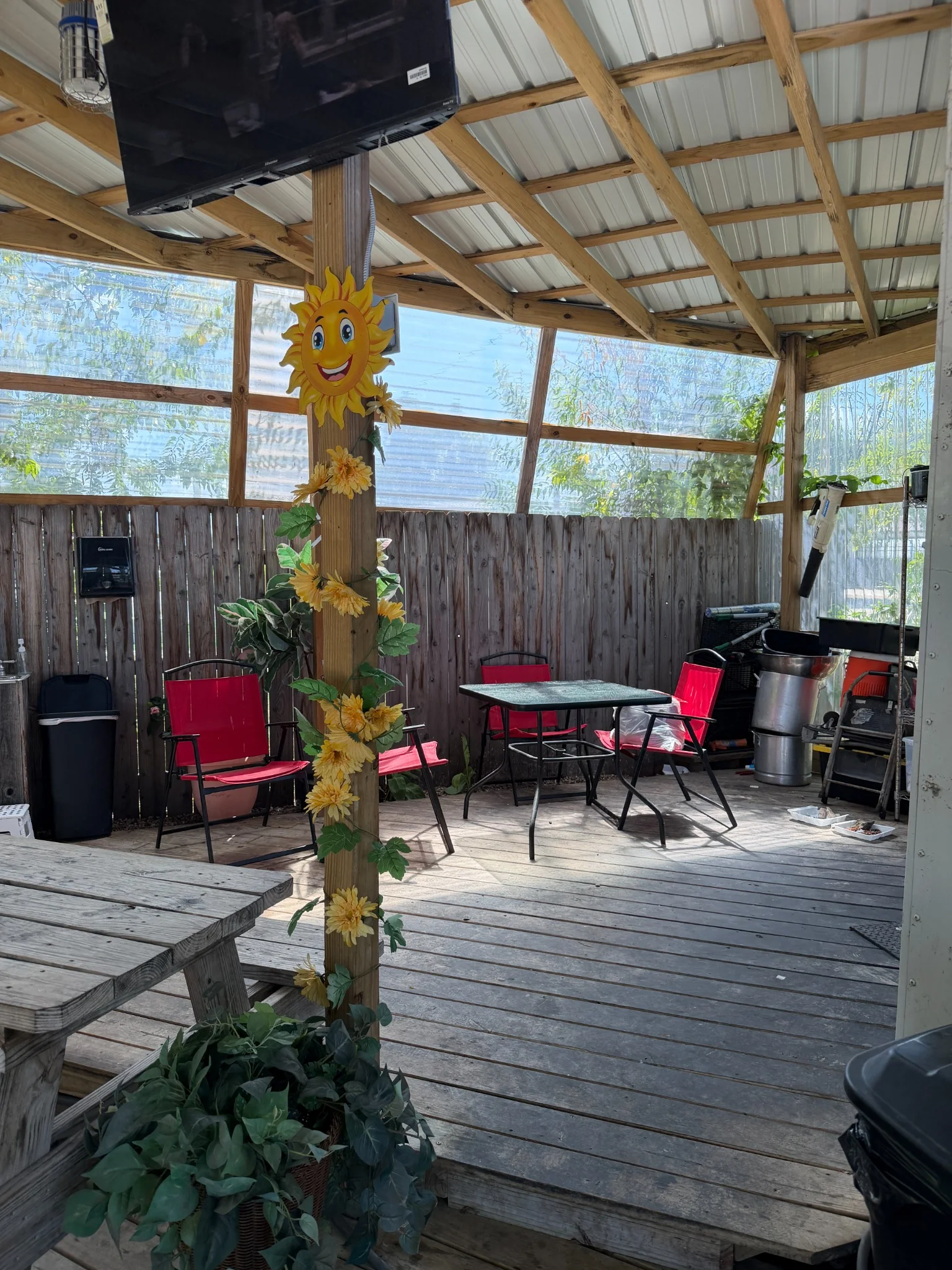 Wooden covered patio with picnic tables and sunflower decorations