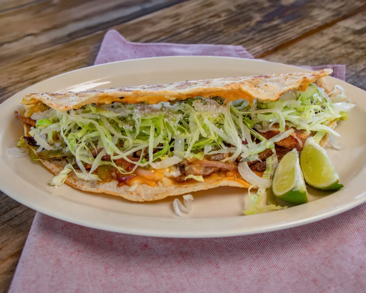 Long folded Machete filled with meat, cheese, lettuce, poblano chiles and cotija cheese, served with lime.