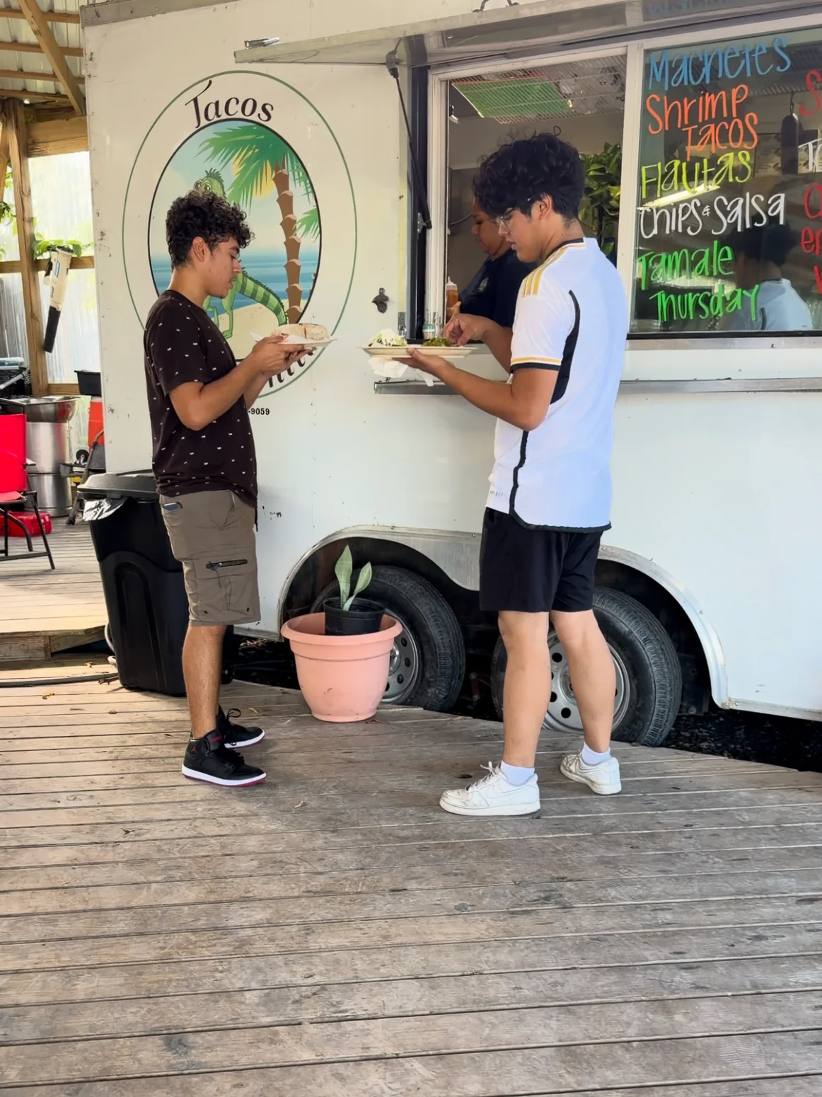 Customers eating beside the Tacos La Costeñita service window